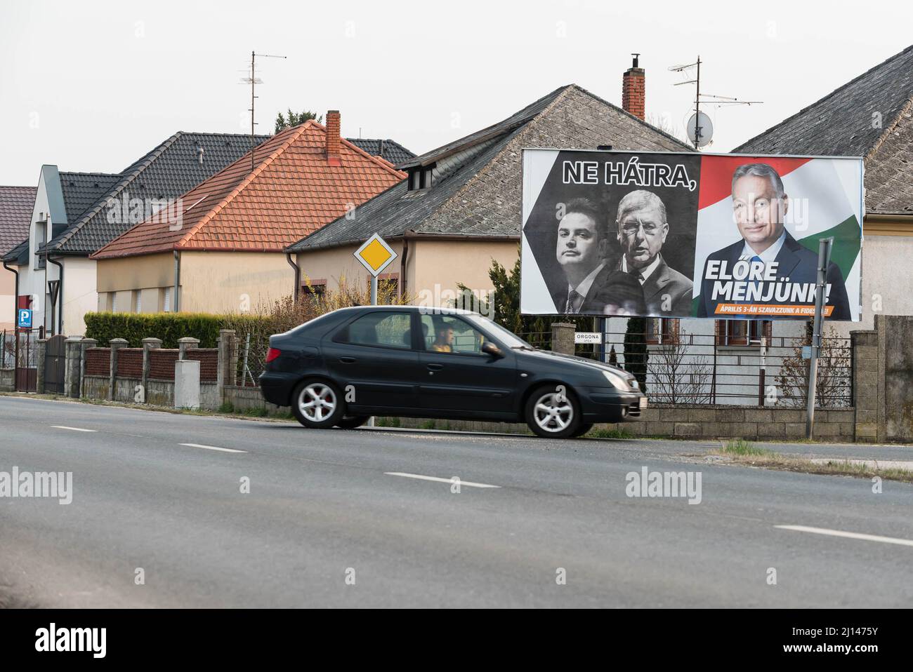Car pass by election billboard for Fidesz party placed on the street of Mosonmagyarovar. On the billboard (from left to right) the leader of opposition Peter Marki-Zay, former prime minister Ferenc Gyurcsany, and Hungarian prime minister and leader of Fidesz Viktor Orban. Mosonmagyarovar is the town in northwest Hungary located approx. 160 kilometers from Hungarian capital Budapest. Peter Marki-Zay will challenge prime minister Viktor Orban in the upcoming parliamentary elections, which will be held on the 3rd of April 2022. Stock Photo