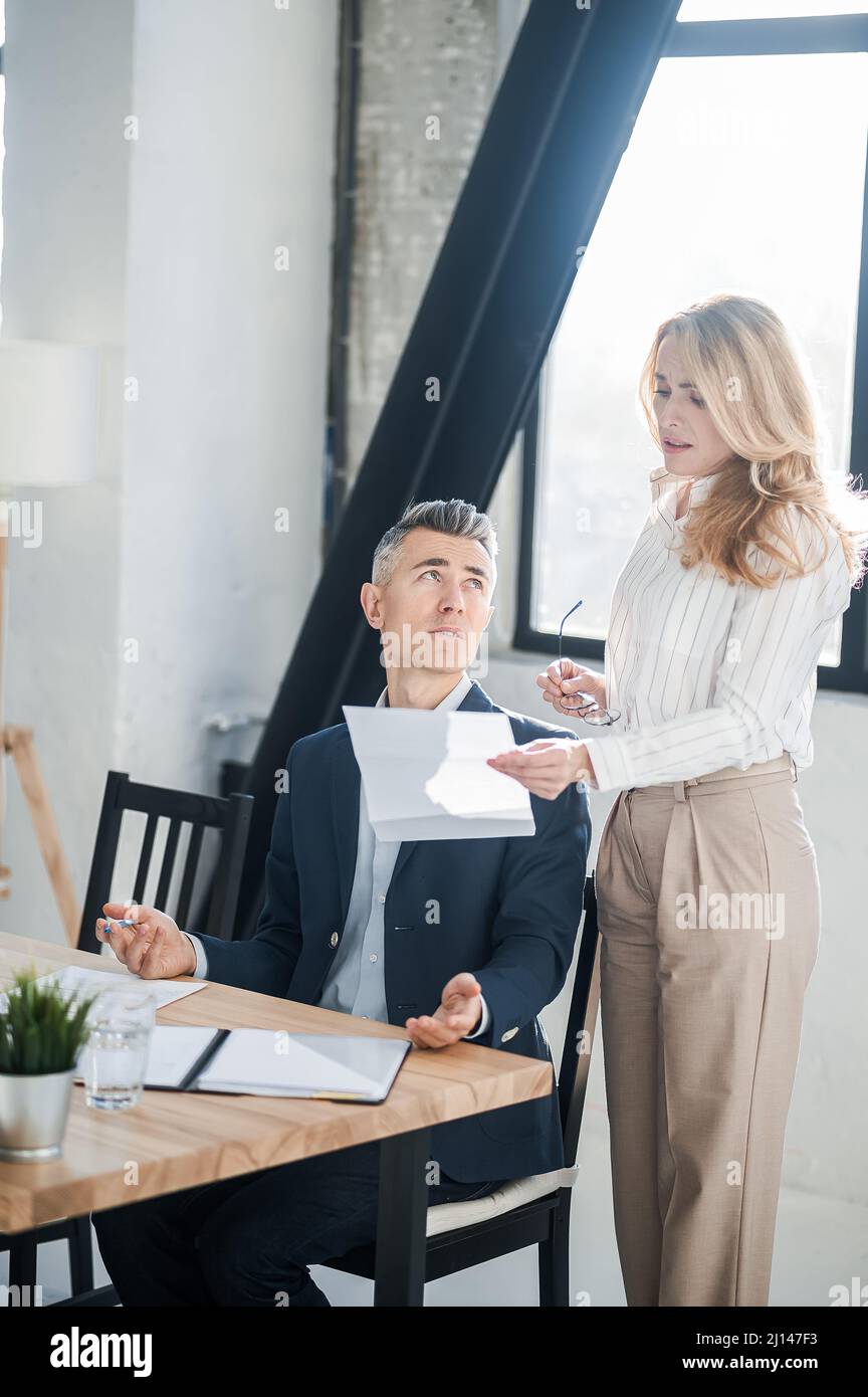 Blonde woman showing na document to her boss Stock Photo