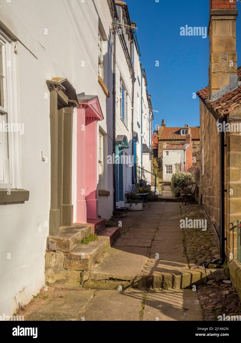 Traditional white rendered seaside cottages situated along a narrow back alley in Robin Hood's Bay, North Yorkshire. UK Stock Photo
