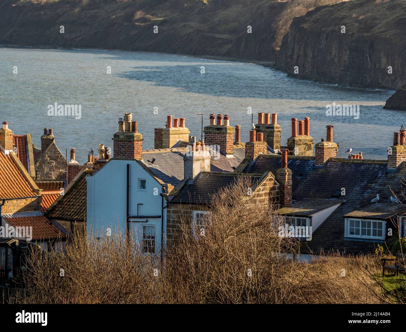 Robin Hood's Bay with house roofs and chimneys in the foreground, North ...