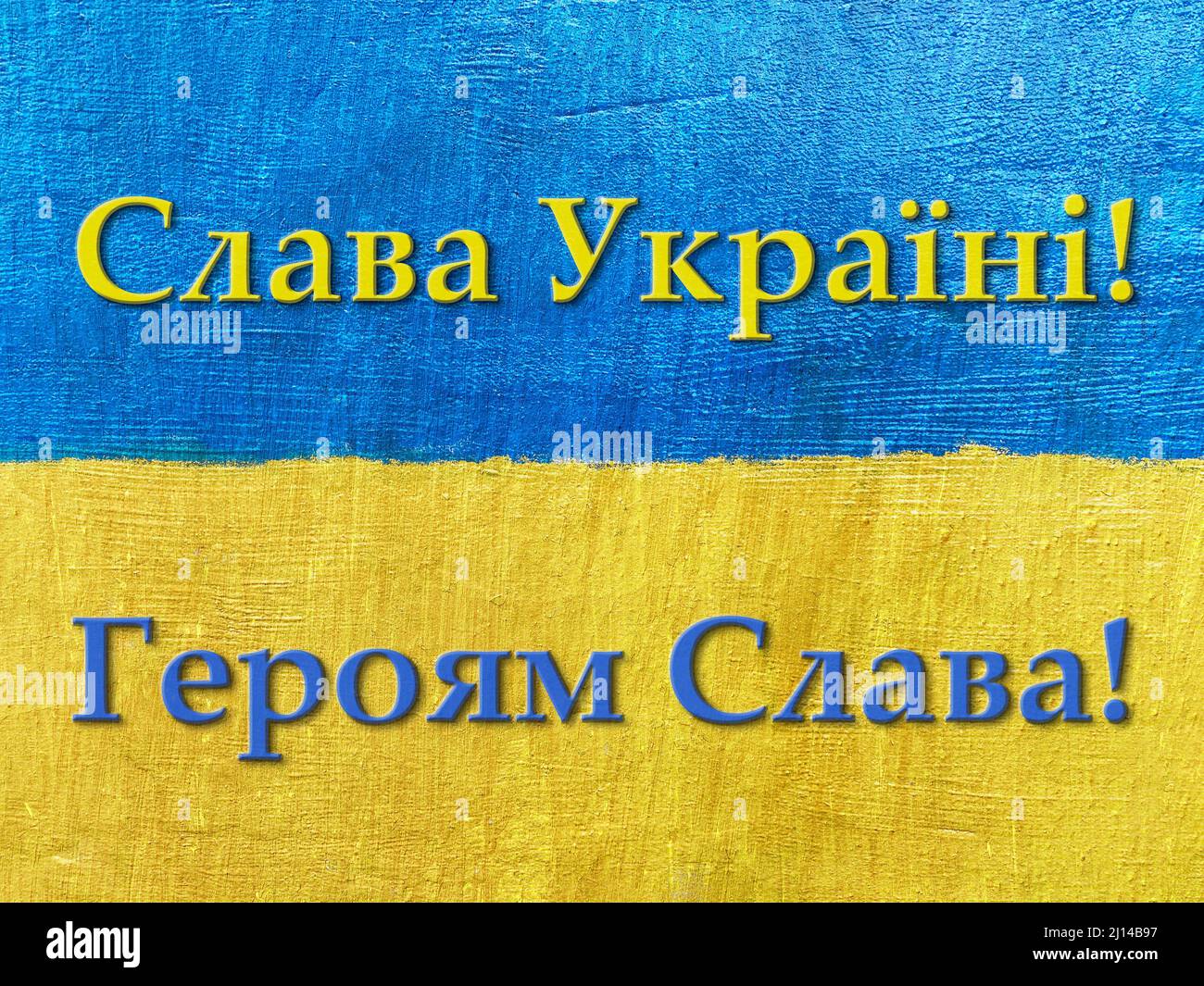 message Glory to Ukraine, Glory to Heroes in Ukrainian on flag painted on wall Stock Photo