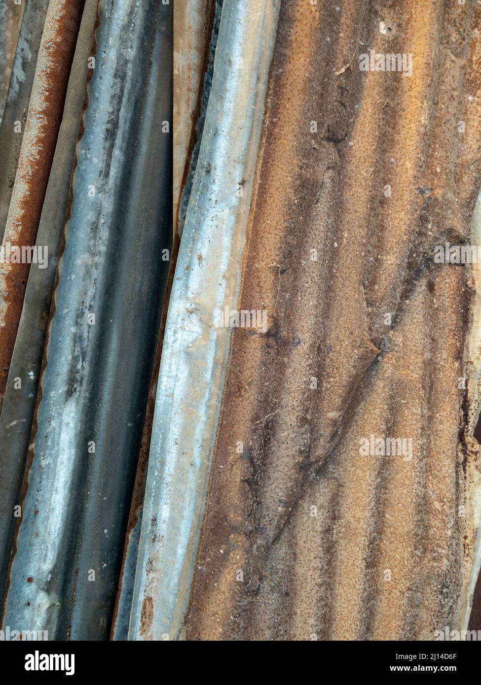 The pile of the old zinc sheet after the removal from the temporary worker house in the construction site, front view for the background. Stock Photo
