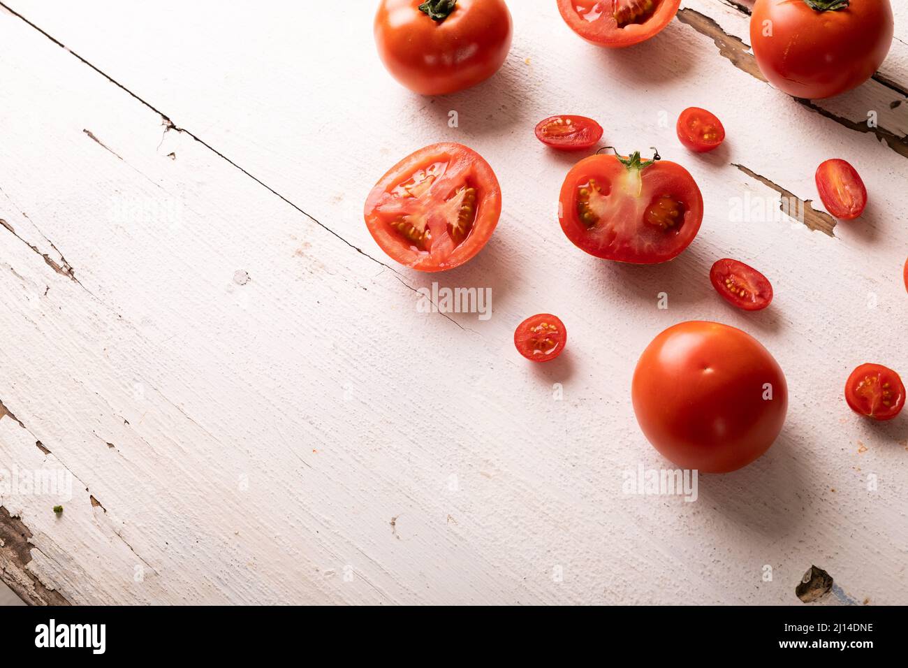 Overhead view of fresh red tomato variations on white wooden table Stock Photo