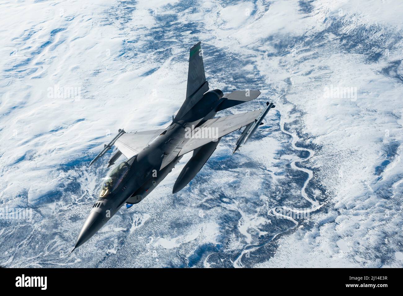 Central Alaska, United States. 16 March, 2022. A U.S. Air Force F-16 Fighting Falcon fighter jet, assigned to 180th Fighter Wing, banks away after refueling from a KC-135R Stratotanker during Operation Arctic Edge, March 16, 2022 over Alaska. The Northern Command Exercise is part of recent military moves to deter Russian involvement in Ukraine.  Credit: SSgt. Taylor Crul/U.S. Air Force/Alamy Live News Stock Photo