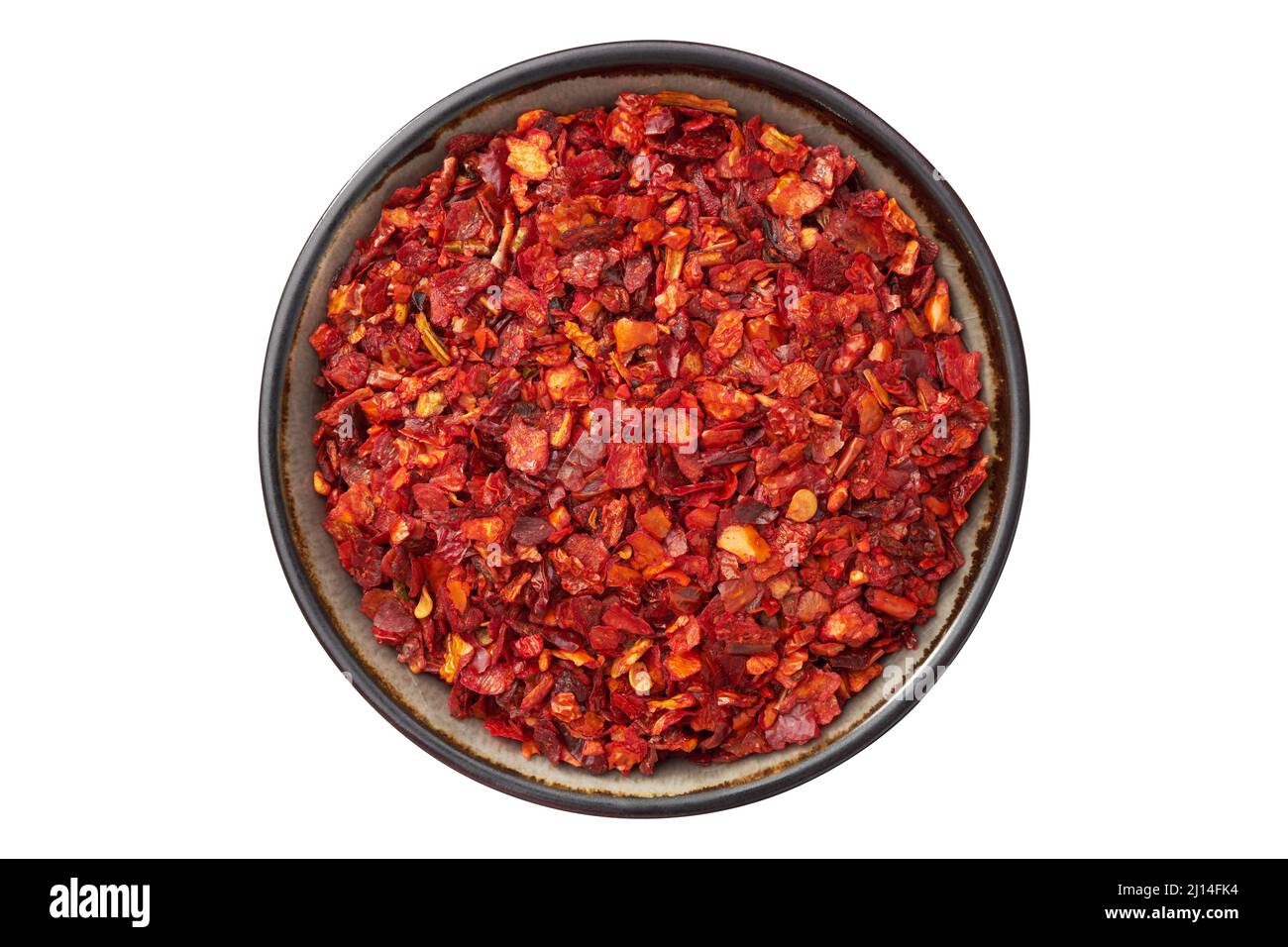 Bowl of dried paprika and hot pepper flakes, isolated on white. Pepper