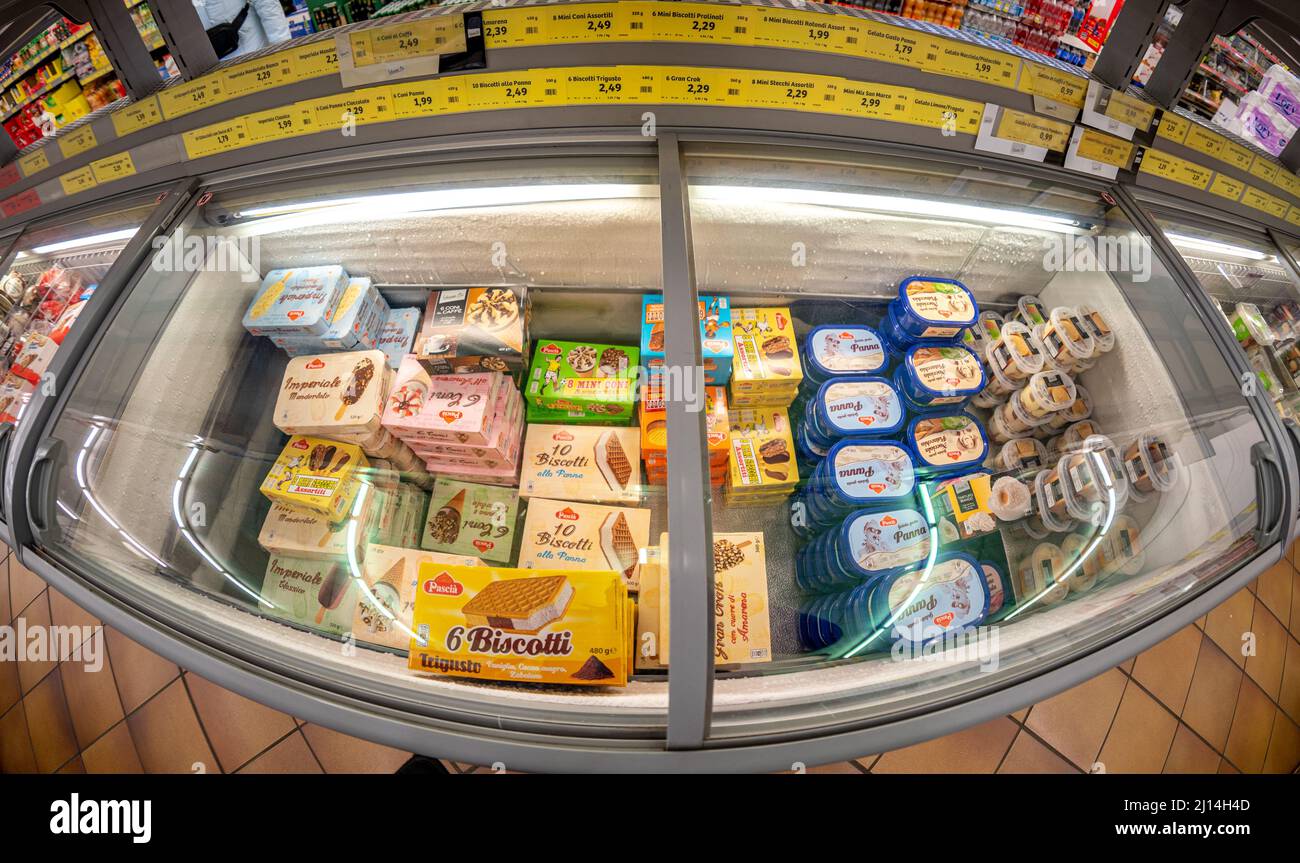 Fossano, Italy - March 12, 2022: Refrigerated counter with packs of ice creams for sale in INS supermarket discount store, PAM group. Fish eye vision Stock Photo