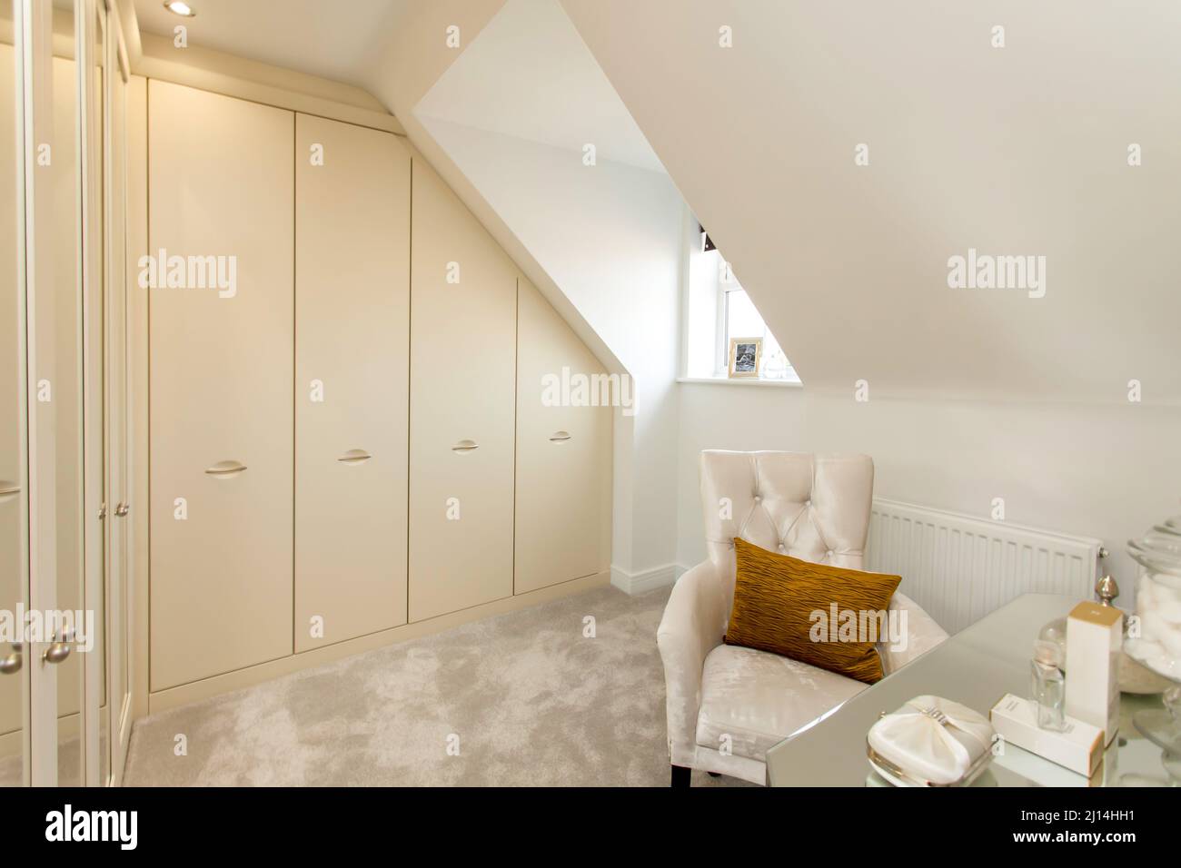 Changing room with fitted wardrobes in cream beige neutral colour scheme Stock Photo