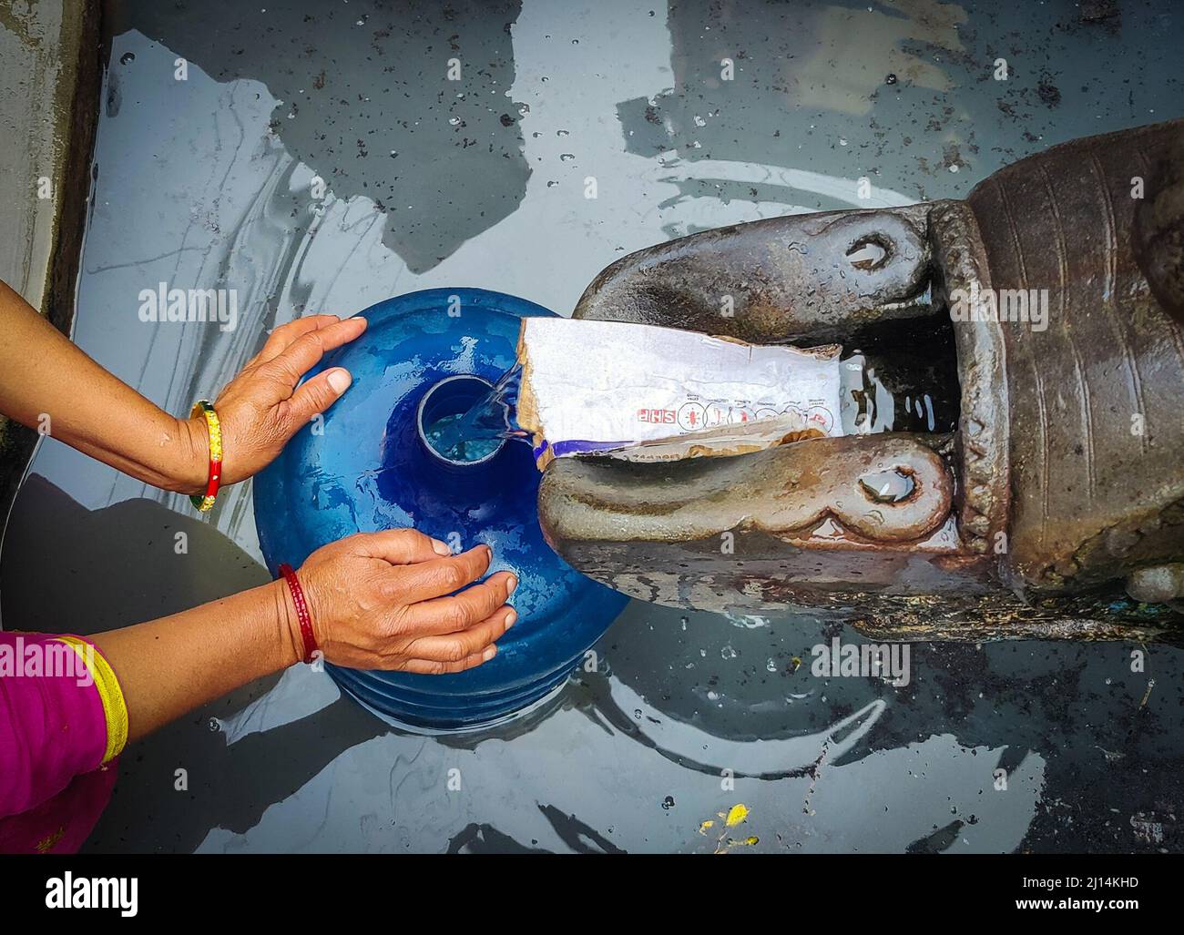 Kathmandu, Bagmati, Nepal. 22nd Mar, 2022. A Nepali woman fills water from a traditional stone tap in Kathmandu, Nepal, March 22, 2022, the World Water Day. People of Kathmandu valley still face the problem of scarcity of drinking water due to increasing population and urbanisation. (Credit Image: © Sunil Sharma/ZUMA Press Wire) Stock Photo