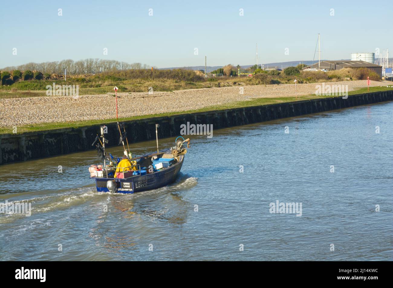 Small commercial fishing boat returning to harbour at Littlehampton in