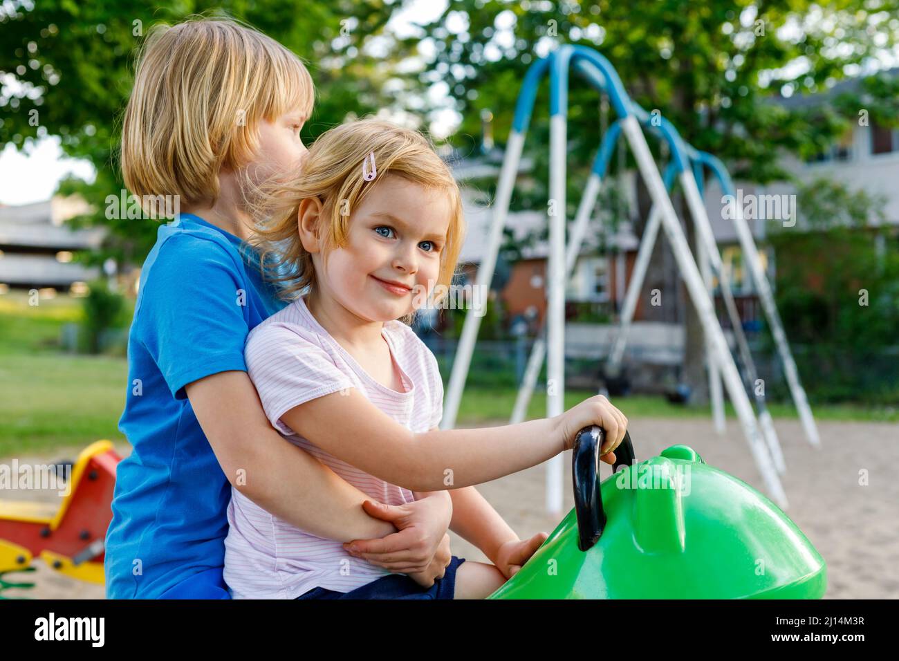 Children in park in summer. Brother hugging little sister. Siblings