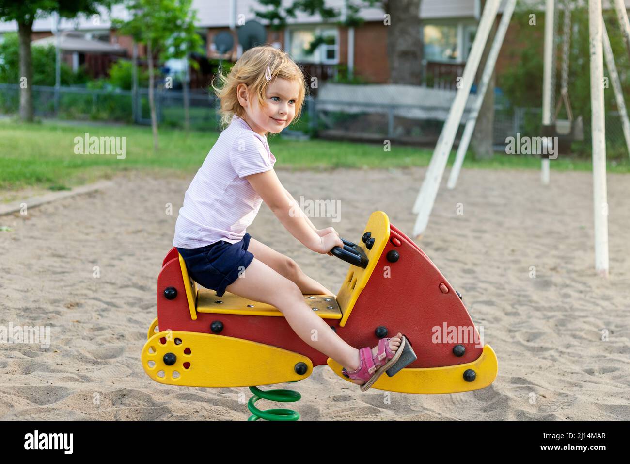 Happy child at playground on a sunny summer day. Smiling little girl in ...