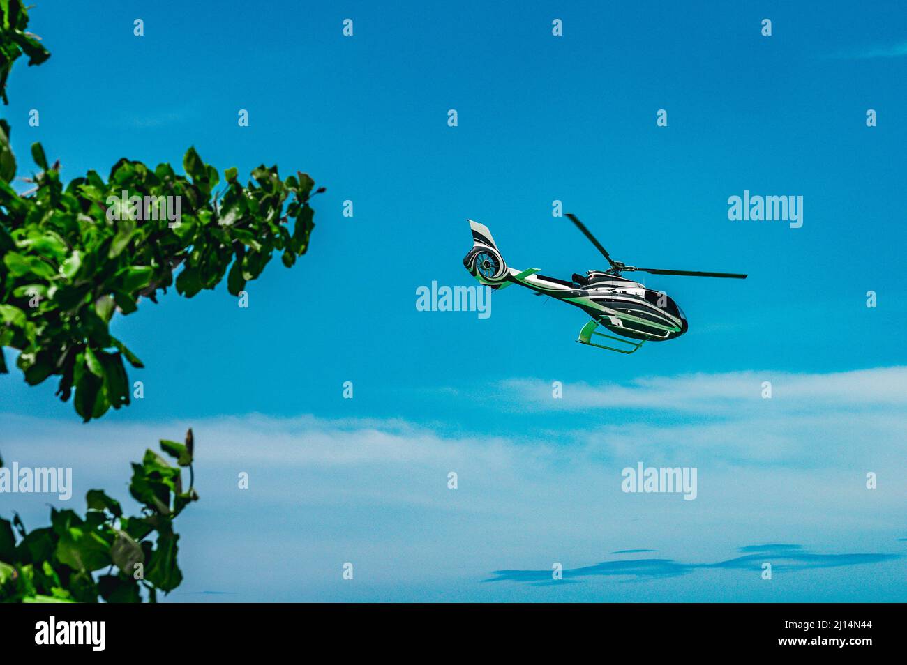The photo shows a helicopter that brought tourists to the beach to relax. A business aviation helicopter was trying to land directly on the sand. It c Stock Photo