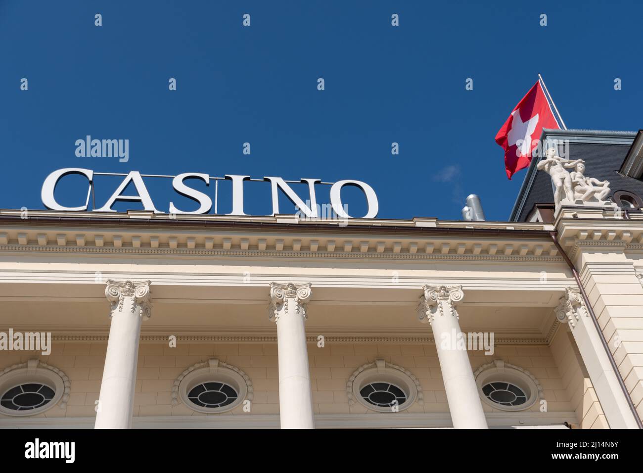 Lucerne, Switzerland, March 10, 2022 Waving swiss flag on the roof top of the casino in the city center Stock Photo