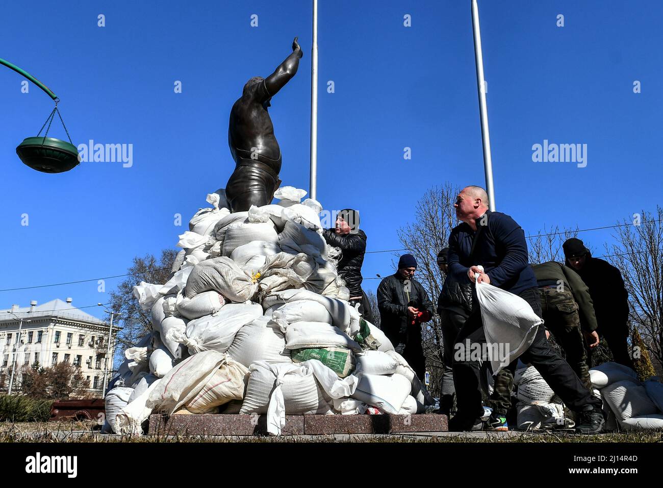 ZAPORIZHZHIA, UKRAINE - MARCH 22, 2022 - Local volunteers, historians and museum employees put sandbags around the monument to Ukrainian weightlifter, Stock Photo