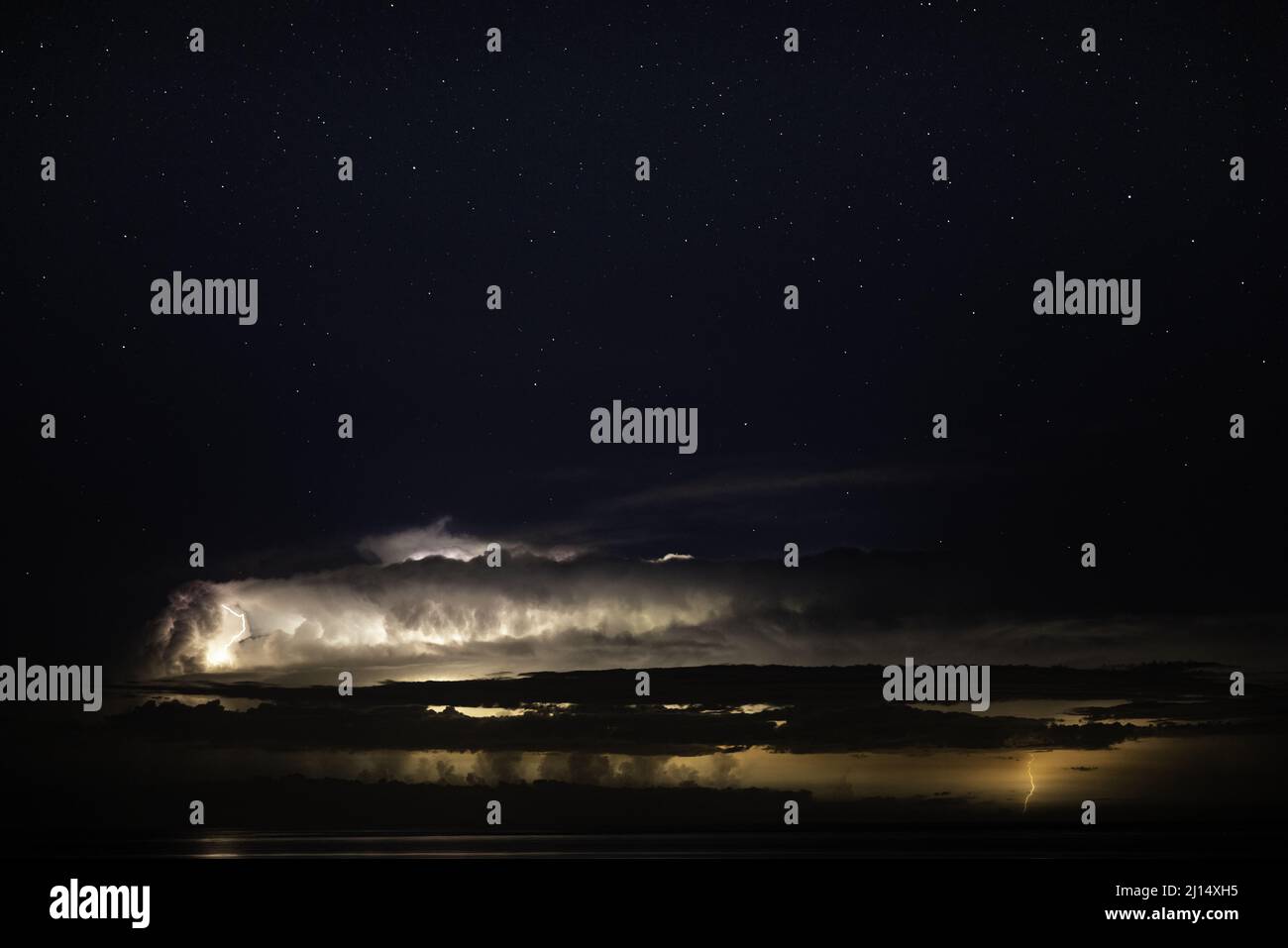 Beautiful shot of a starry night sky with lightning over the lake Stock Photo