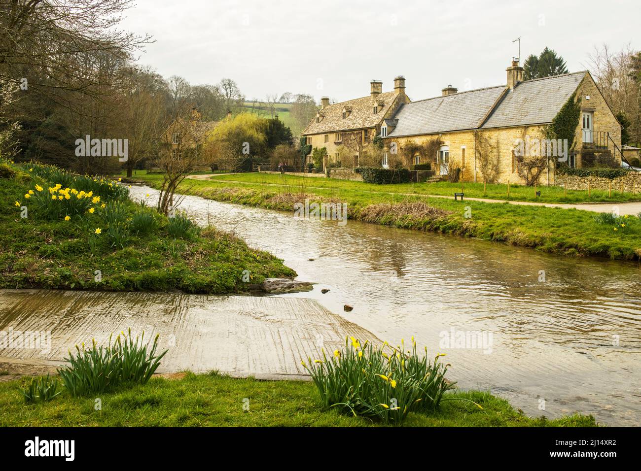 The River Eye running through Upper Slaughter in Gloucestershire in the Cotswolds in March. Stock Photo