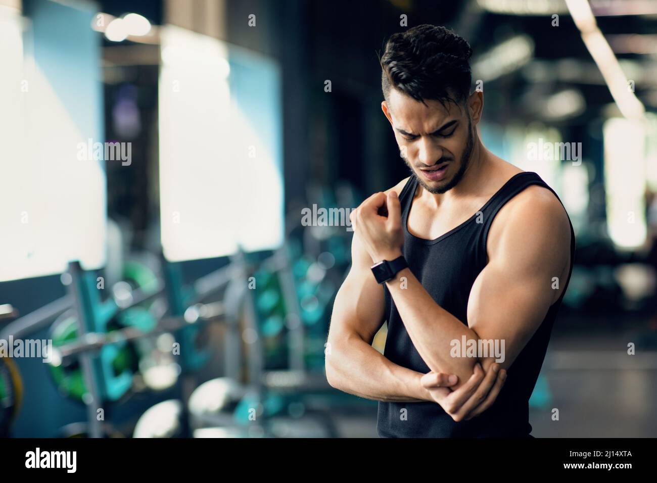 Sport Injuries. Upset Arab Male Athlete Rubbing Injured Elbow While