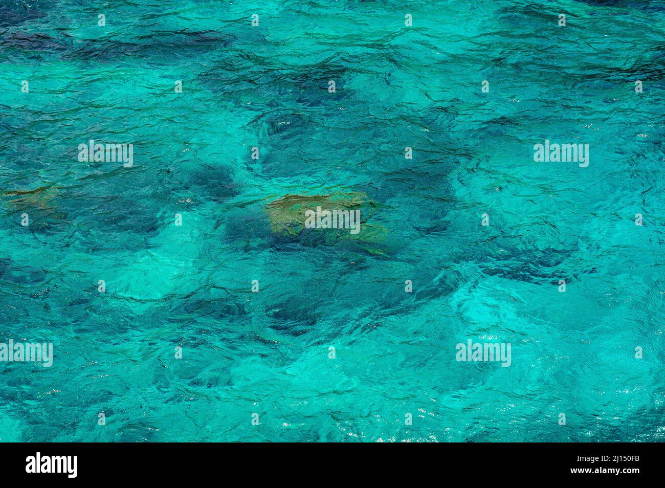 Photo shows texture of ocean. Surface of sea is turquoise. Ocean water pattern is light and in different shades of blue. Background of sea water is tr Stock Photo