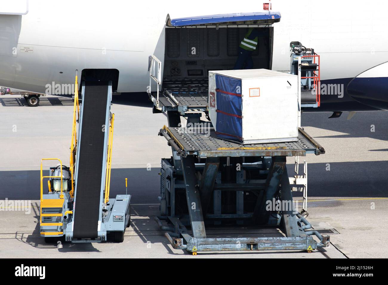 unit load devices being loaded into airliner at international airport Stock Photo