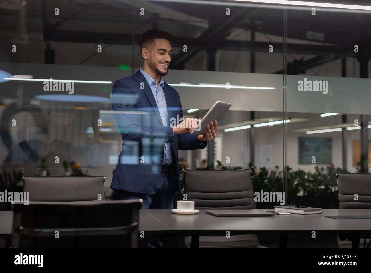 Positive middle eastern manager using digital tablet at office Stock Photo