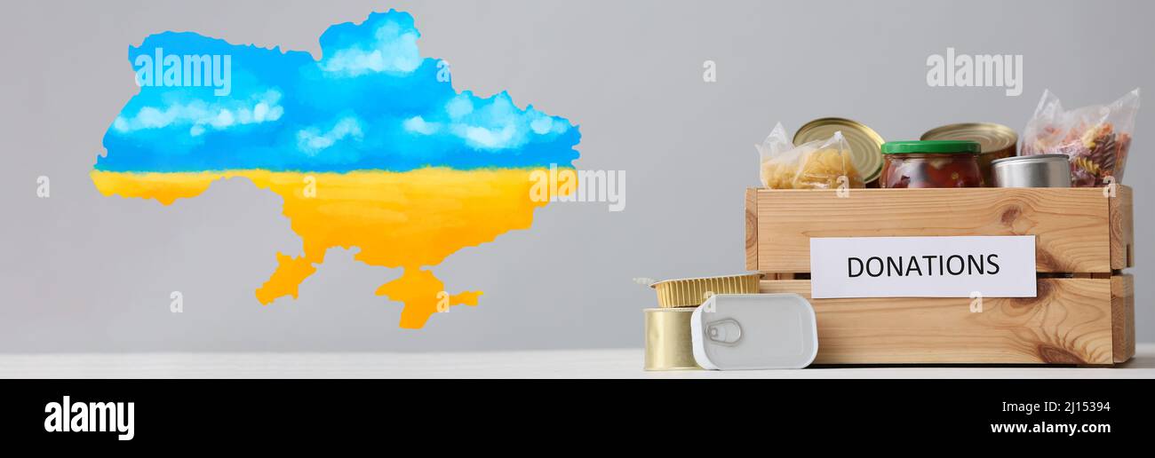 Donation box with products and map of Ukraine on light background