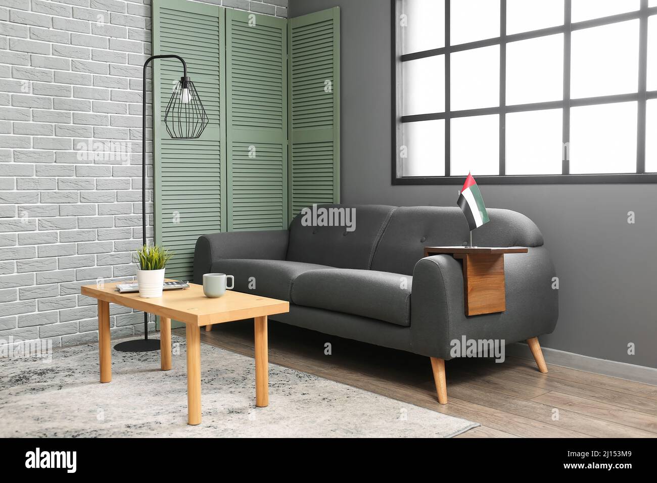 Interior of living room with black sofa, table and UAE flag Stock Photo