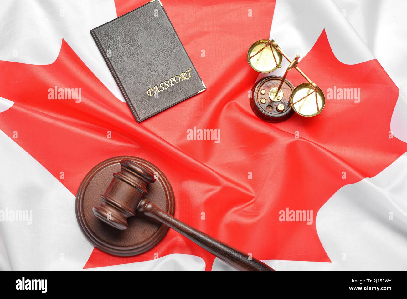 Scales of justice, passport and judge's gavel on Canadian flag Stock