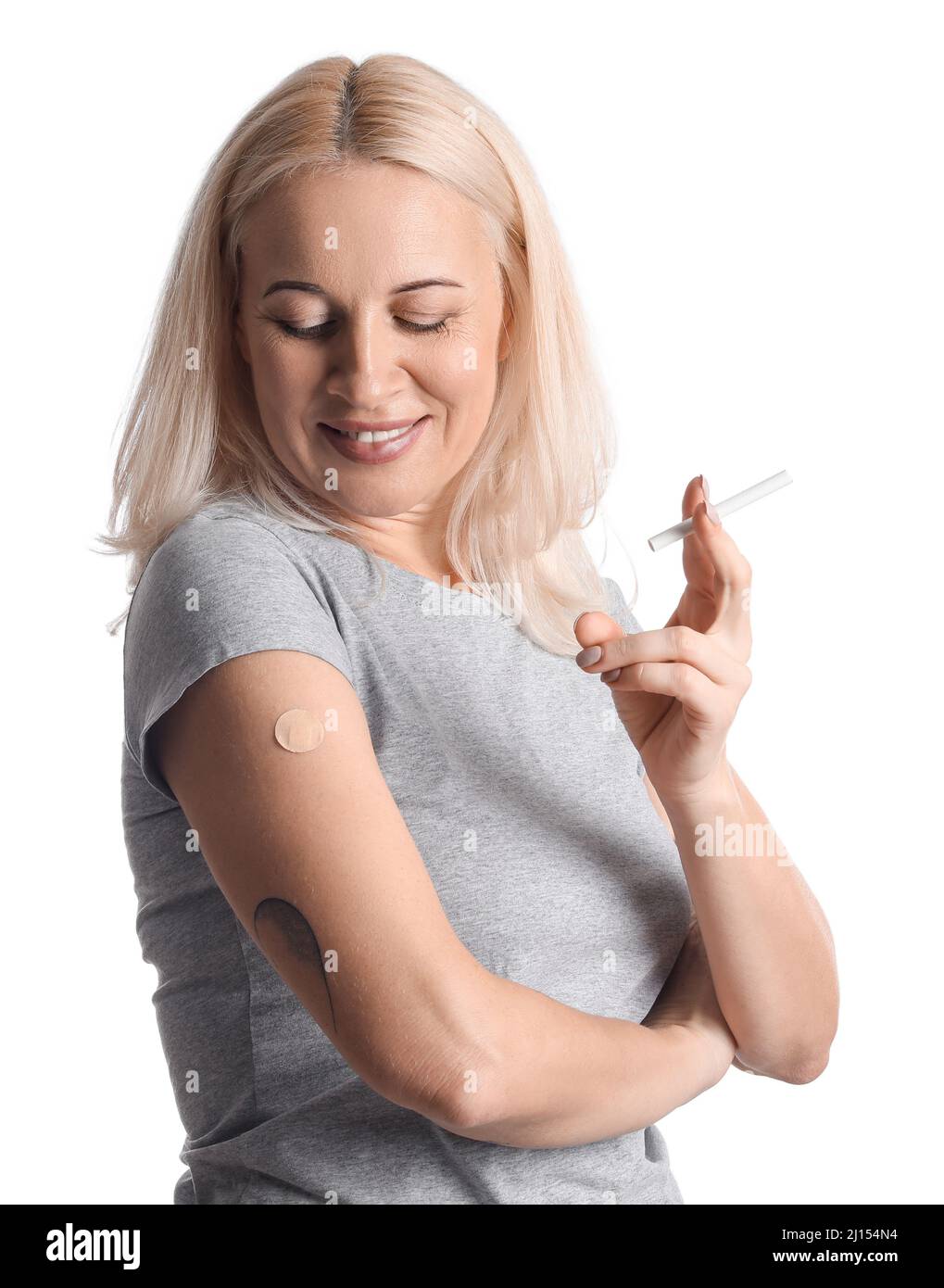 Mature woman with applied nicotine patch and cigarette on white background. Smoking cessation