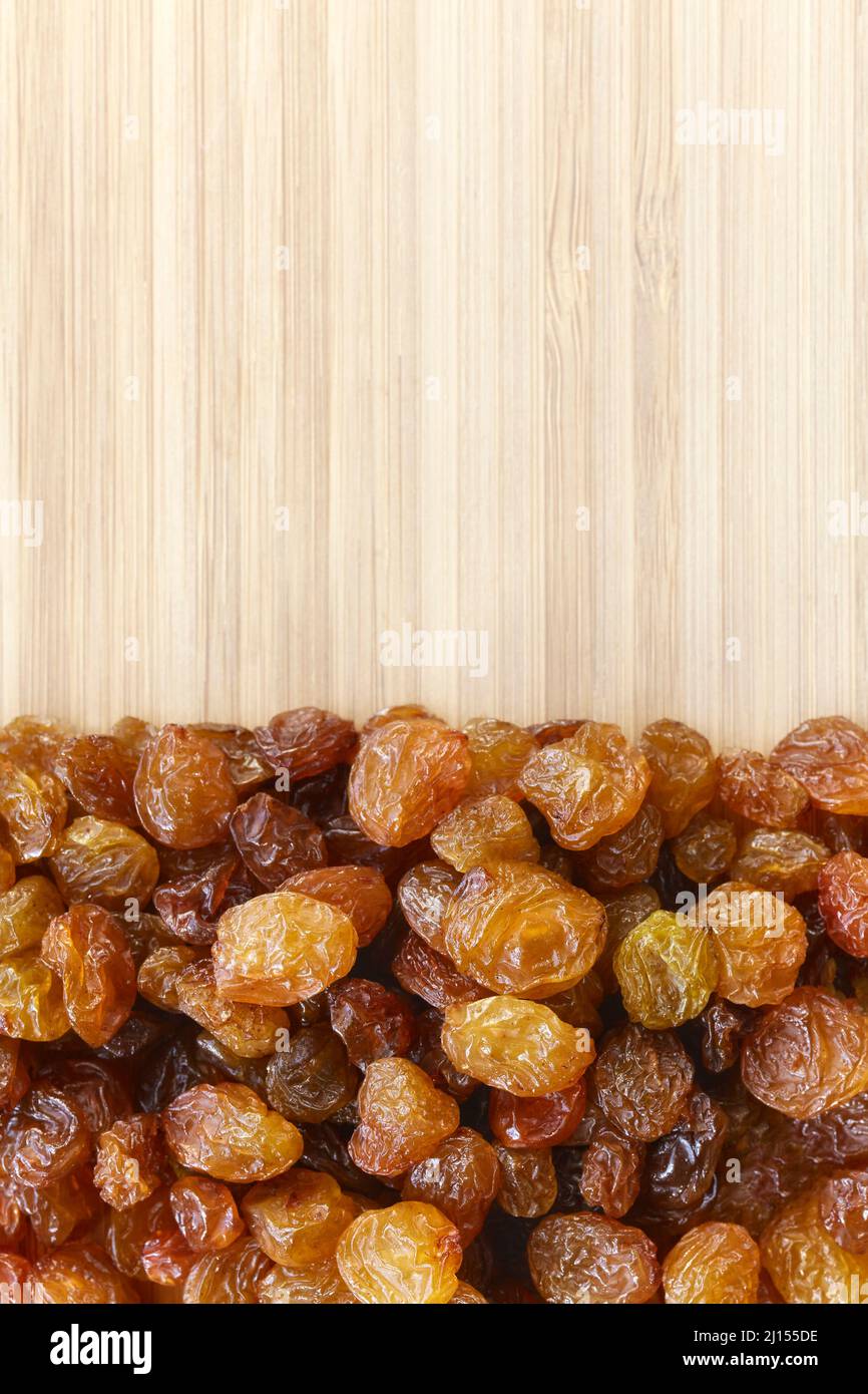 Close up picture of small raisins on a wooden background, selective focus. Stock Photo