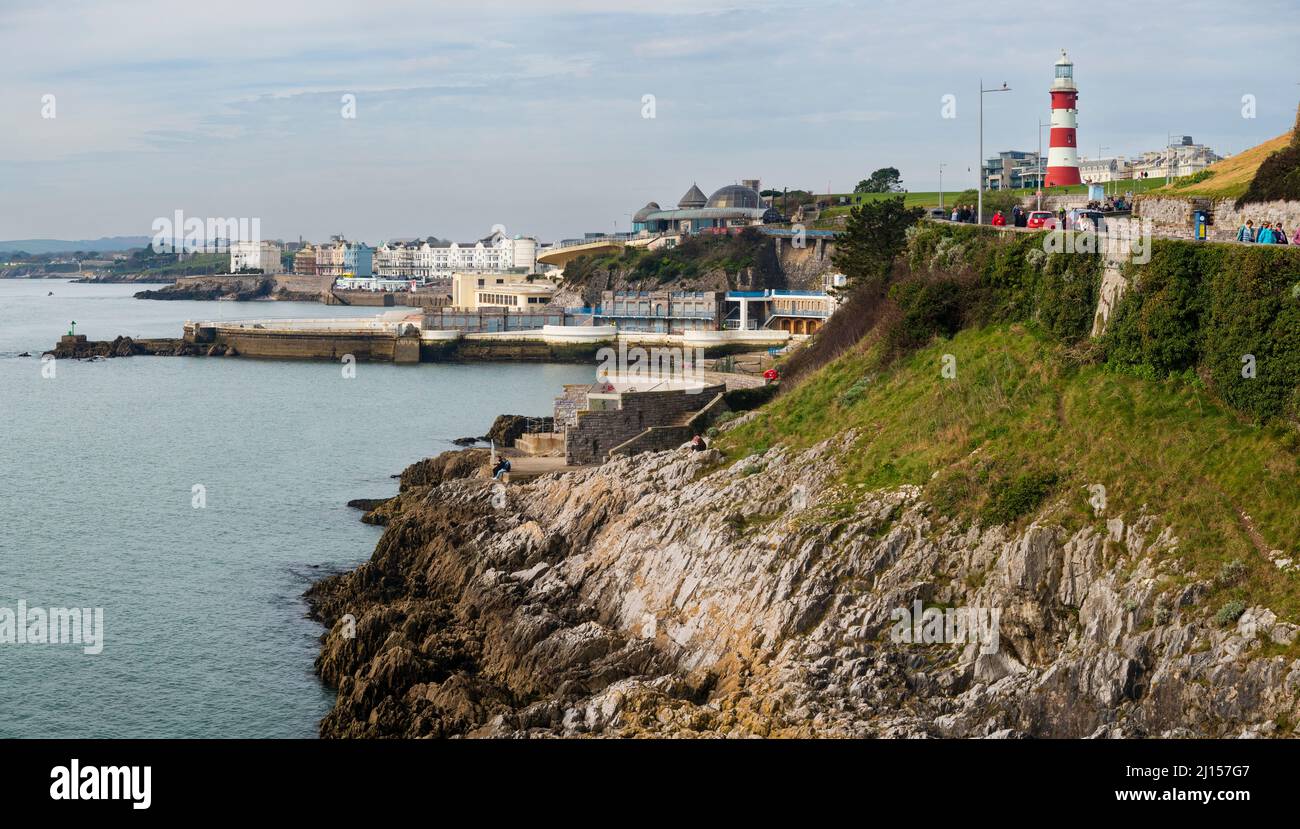 Westerly spring view over the rocky shoreline of Plymouth Hoe, Devon, UK with Smeeton's Tower and Tinside Lido in distance Stock Photo
