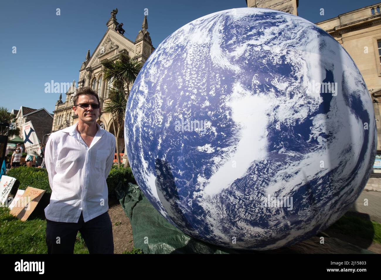 Weston-super-Mare, North Somerset, UK. 20th July 2021. Pictured: Luke Jerram together with one of his 'Gaia' art works outside Weston-super-Mare Town Stock Photo