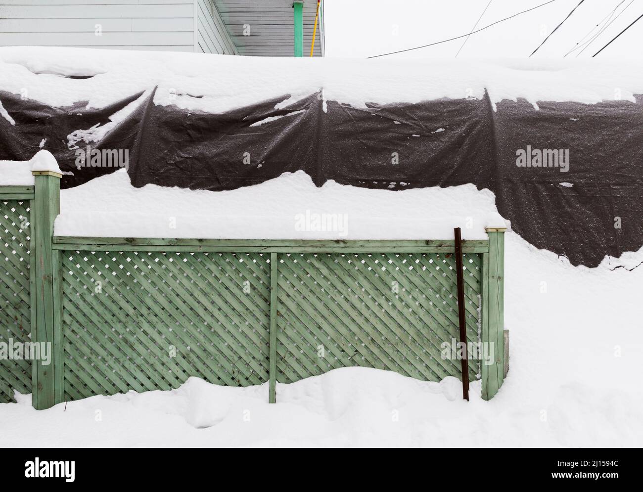 Winter car shelter and fence covered in snow in Longueuil, Quebec