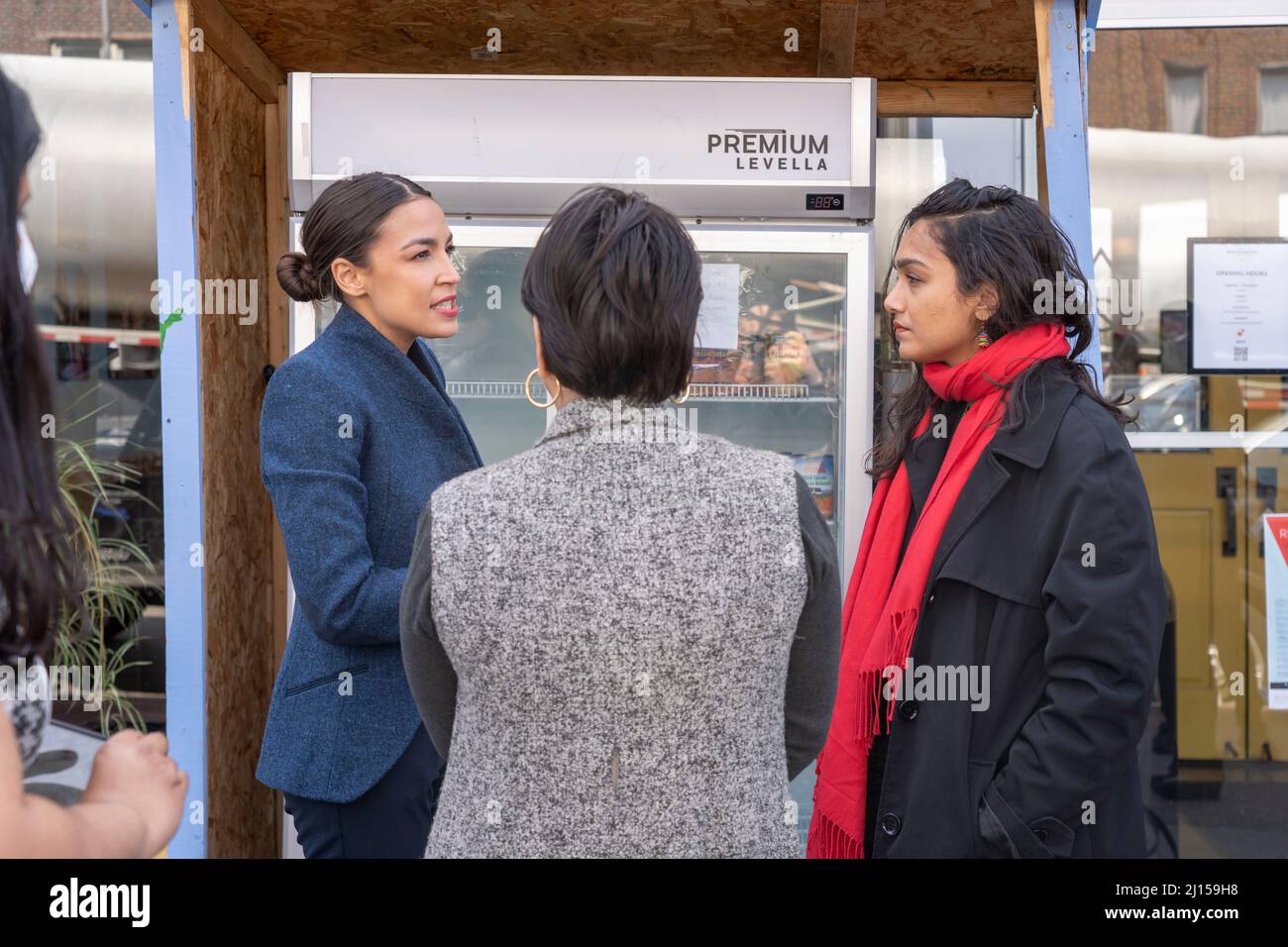 NEW YORK, NY – MARCH 22: United States Congresswoman Alexandria Ocasio-Cortez talks with local activist by a neighborhood fridge outside the Queensboro restaurant in Jackson Heights on March 22, 2022 in New York City.  Representative Alexandria Ocasio-Cortez presents a proclamation honoring the Queensboro restaurant's owners and workers in Jackson Heights neighborhood for serving over 500 meals to community members facing food insecurity during the height of the COVID-19 pandemic. Credit: Ron Adar/Alamy Live News Stock Photo