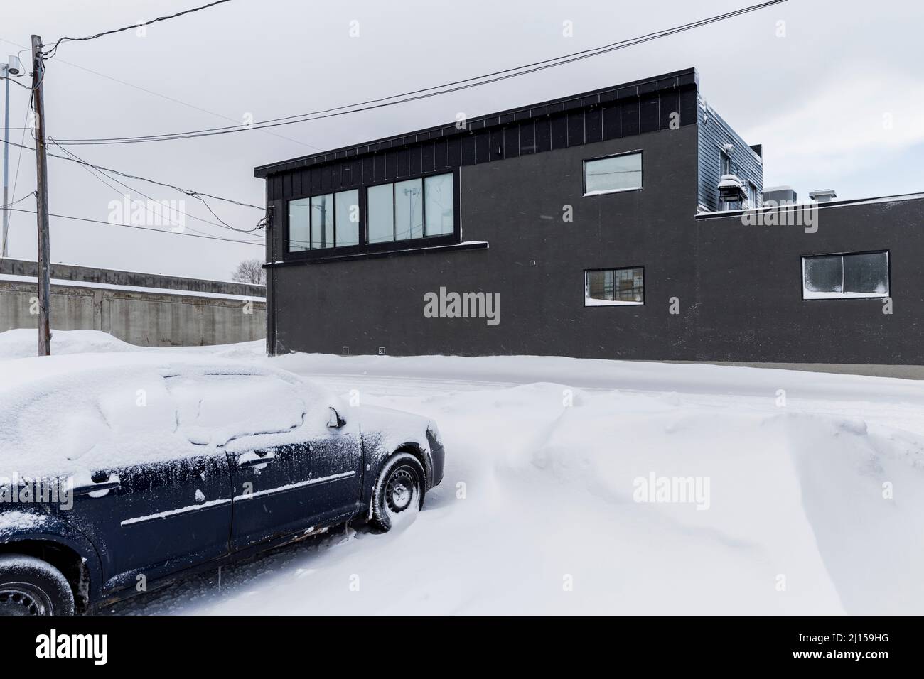 A car covered in snow in a car park during winter in Longueuil, Quebec