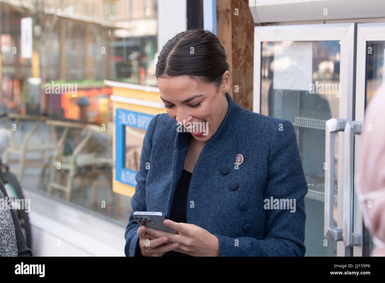 NEW YORK, NY – MARCH 22: United States Congresswoman Alexandria Ocasio-Cortez talks with local activist by a neighborhood fridge outside the Queensboro restaurant in Jackson Heights on March 22, 2022 in New York City.  Representative Alexandria Ocasio-Cortez presents a proclamation honoring the Queensboro restaurant's owners and workers in Jackson Heights neighborhood for serving over 500 meals to community members facing food insecurity during the height of the COVID-19 pandemic. Credit: Ron Adar/Alamy Live News Stock Photo