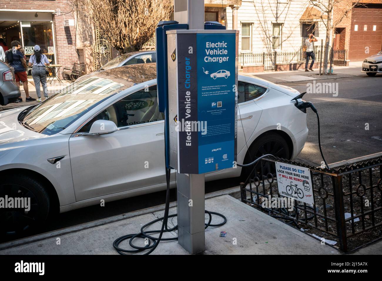 A Tesla electric vehicle is charged at a public charging station in