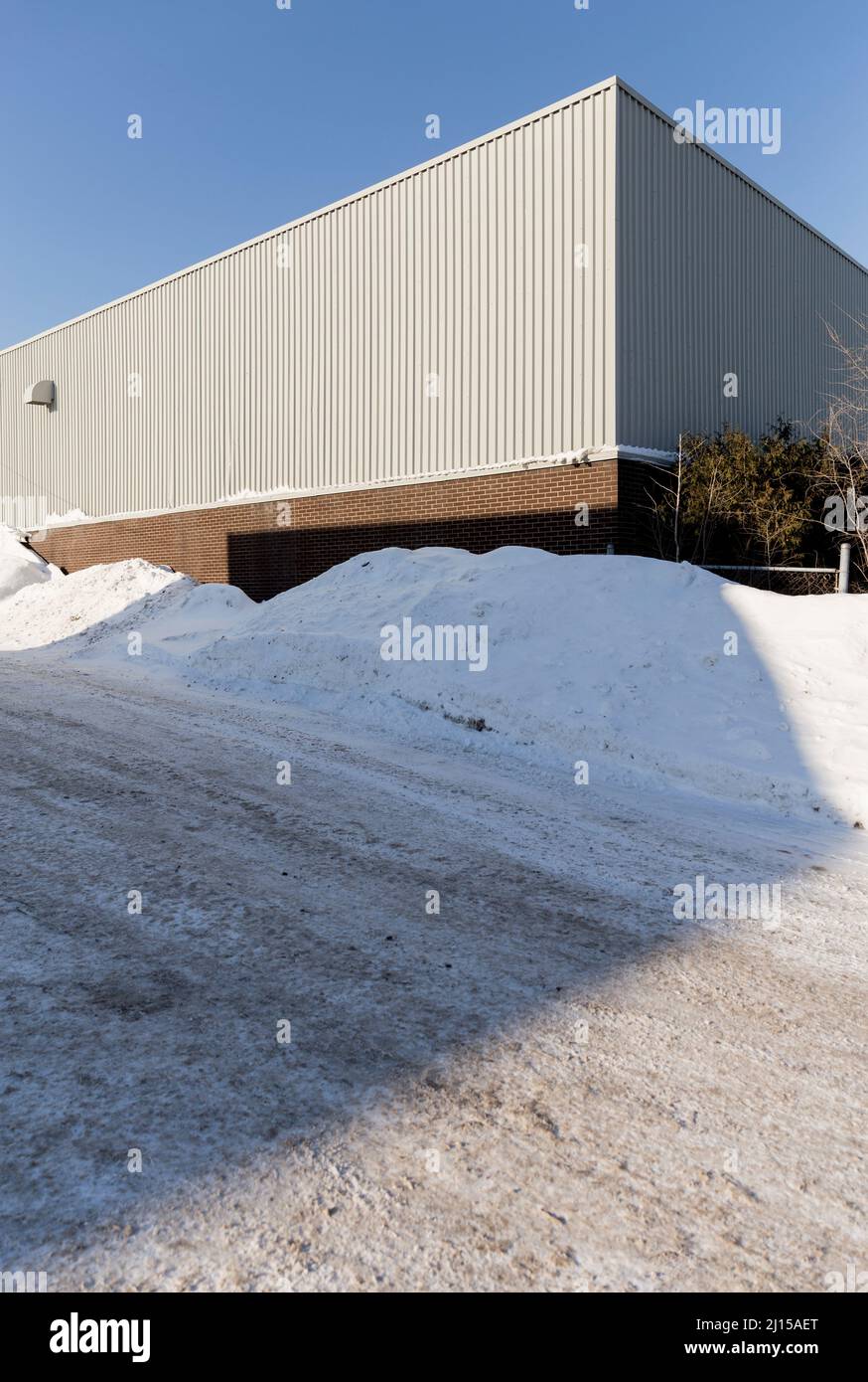 Plain white building and snow pile in the Longueuil area of Montreal