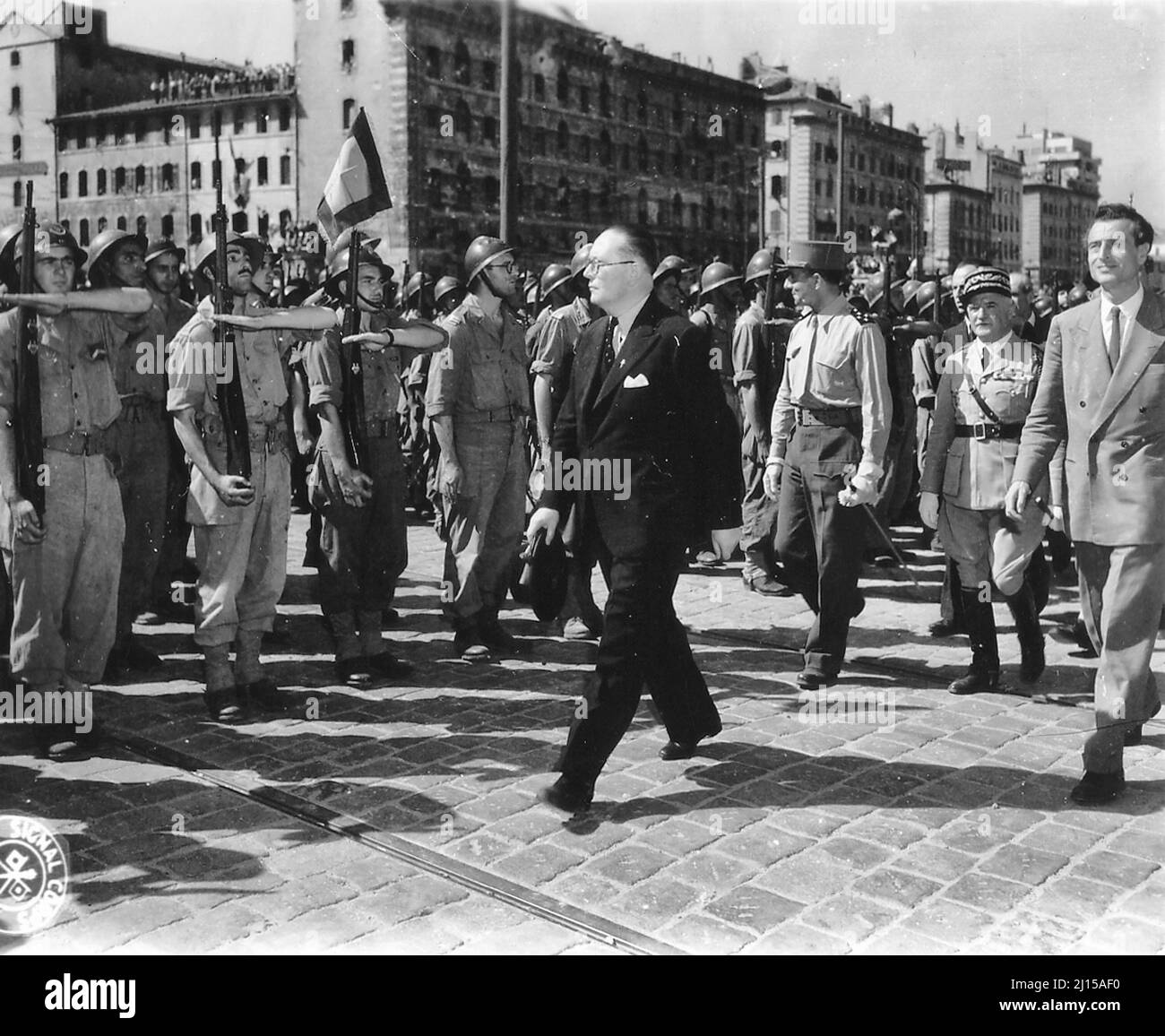 Andre Diethelm reviews troops in Marseille liberated in August 1944. We recognize, behind Diethelm, General de Lattre de Tassigny (in pants and uniform shirt, without jacket, looking to the right of the soldiers) and Emmanuel Astier de La Vigerie, on the right of the photo. Between the two preceding ones, behind Diethelm, in a kepi with oak leaves, General de Monsabert. Photograph taken on the wharf of Rive-Neuve on the corner with the Cours Jean-Ballard - August 1944 Stock Photo