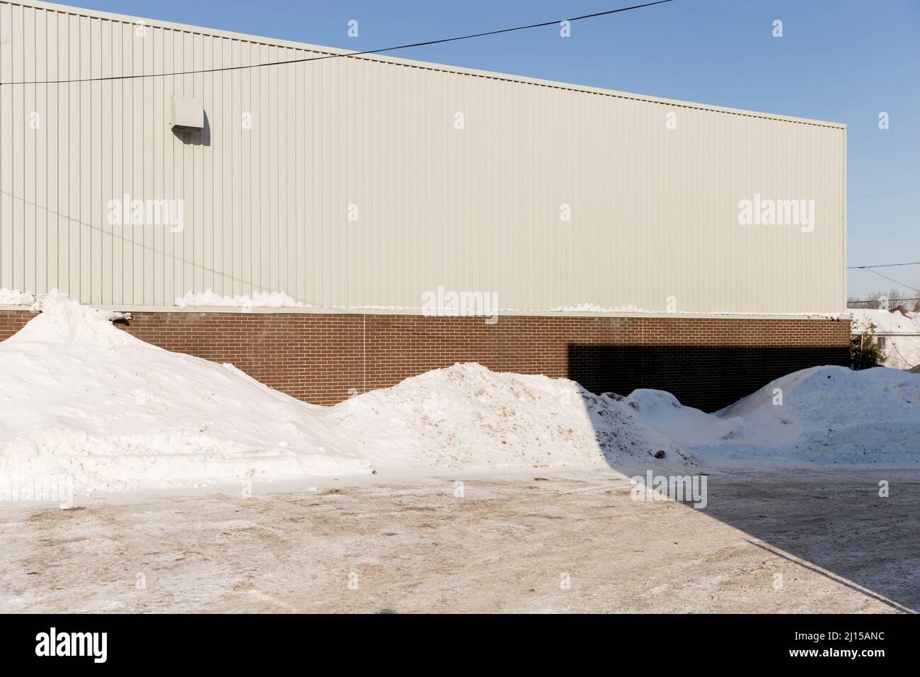 Plain white building and snow pile in the Longueuil area of Montreal