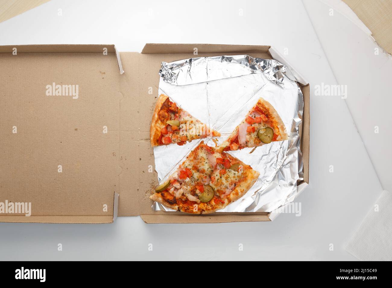 The remaining pizza is in the box. Empty pizza box with three slice