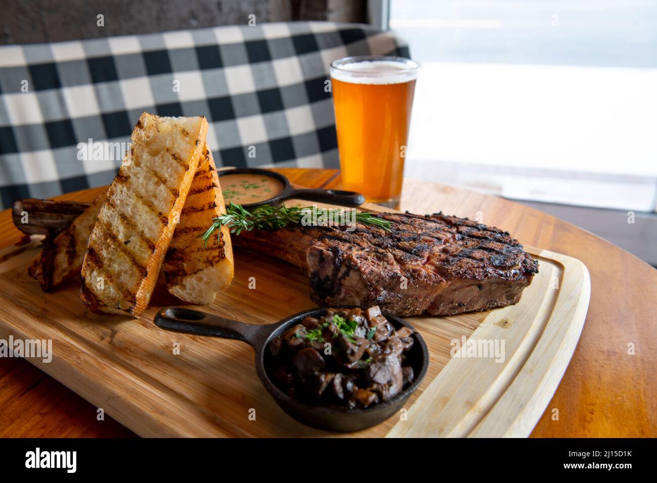 Food Tomahawk steak - ribeye - with mushrooms gravy and bread with a draft beer at a pub in Arlington Virginia called The Pinemoor Stock Photo