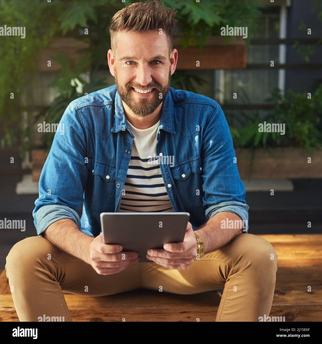 I cant survive without social media at my side. Portrait of a handsome young man using a digital tablet. Stock Photo