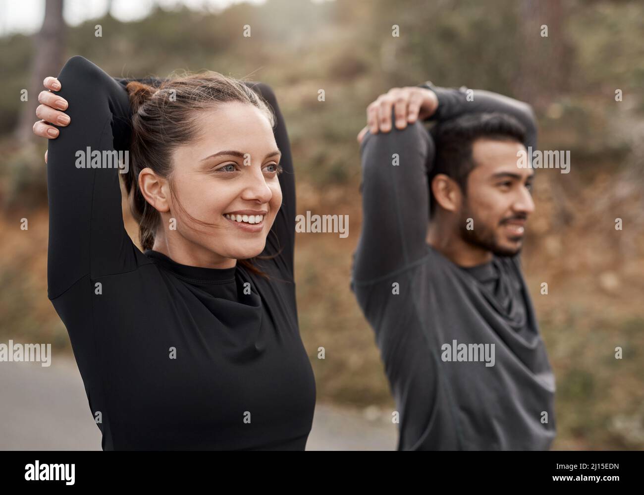 Youre always one run away from a different life. Cropped shot of two young athletes stretching before exercising outdoors together. Stock Photo