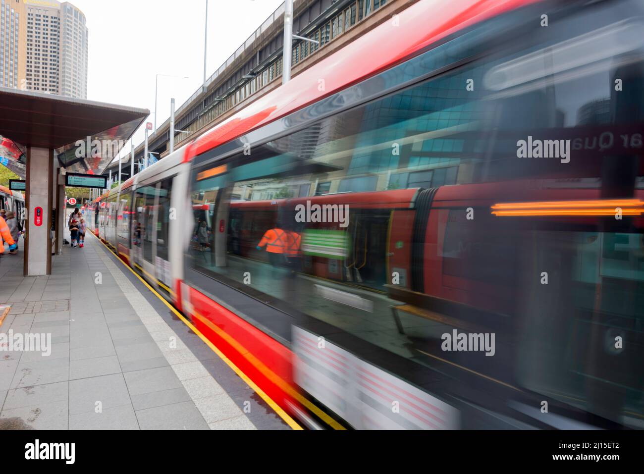 A blurred image of a Sydney Light Rail tram as it moves away from the platform at Circular Quay in central Sydney, New South Wales, Australia Stock Photo