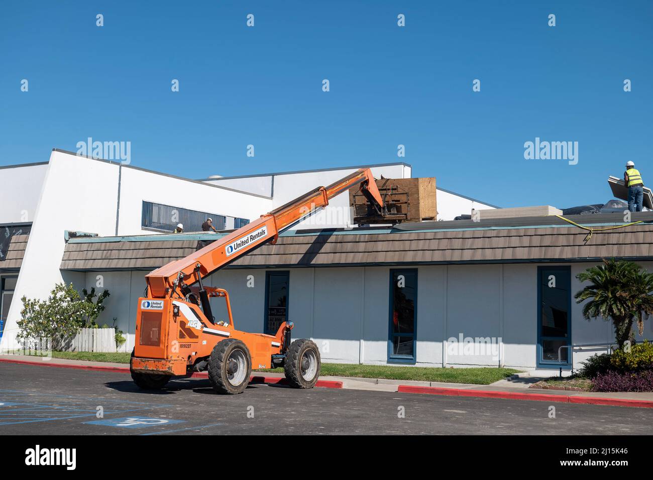 PORT ARANSAS, TX - 29 JAN 2020: Orange hydraulic forklift is used at a building where the roof is being repaired after damage from Hurricane Harvey. Stock Photo