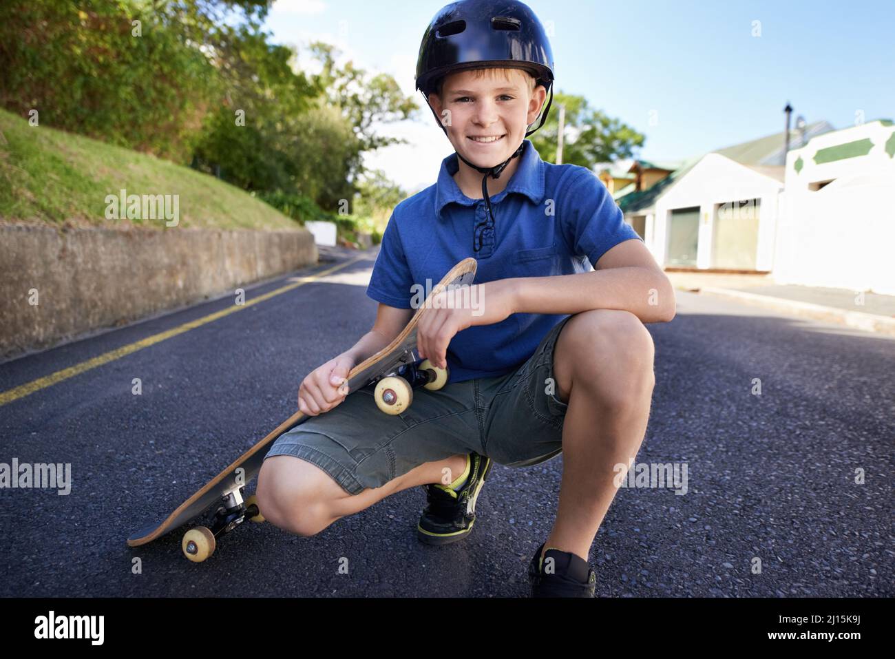 Ready to roll. A young boy with his skateboard. Stock Photo