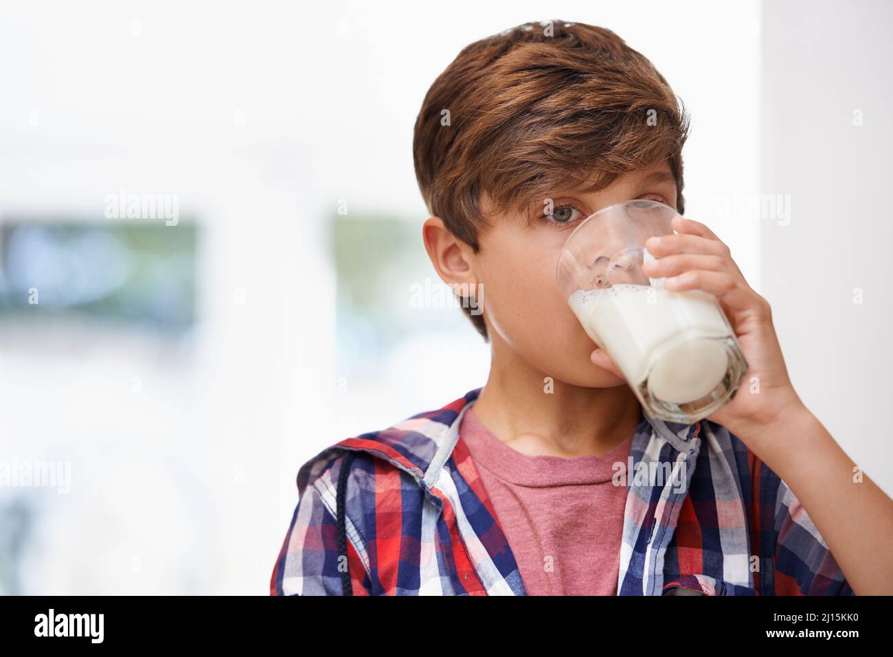 Ah... delicious. A young boy drinking a glass of milk. Stock Photo