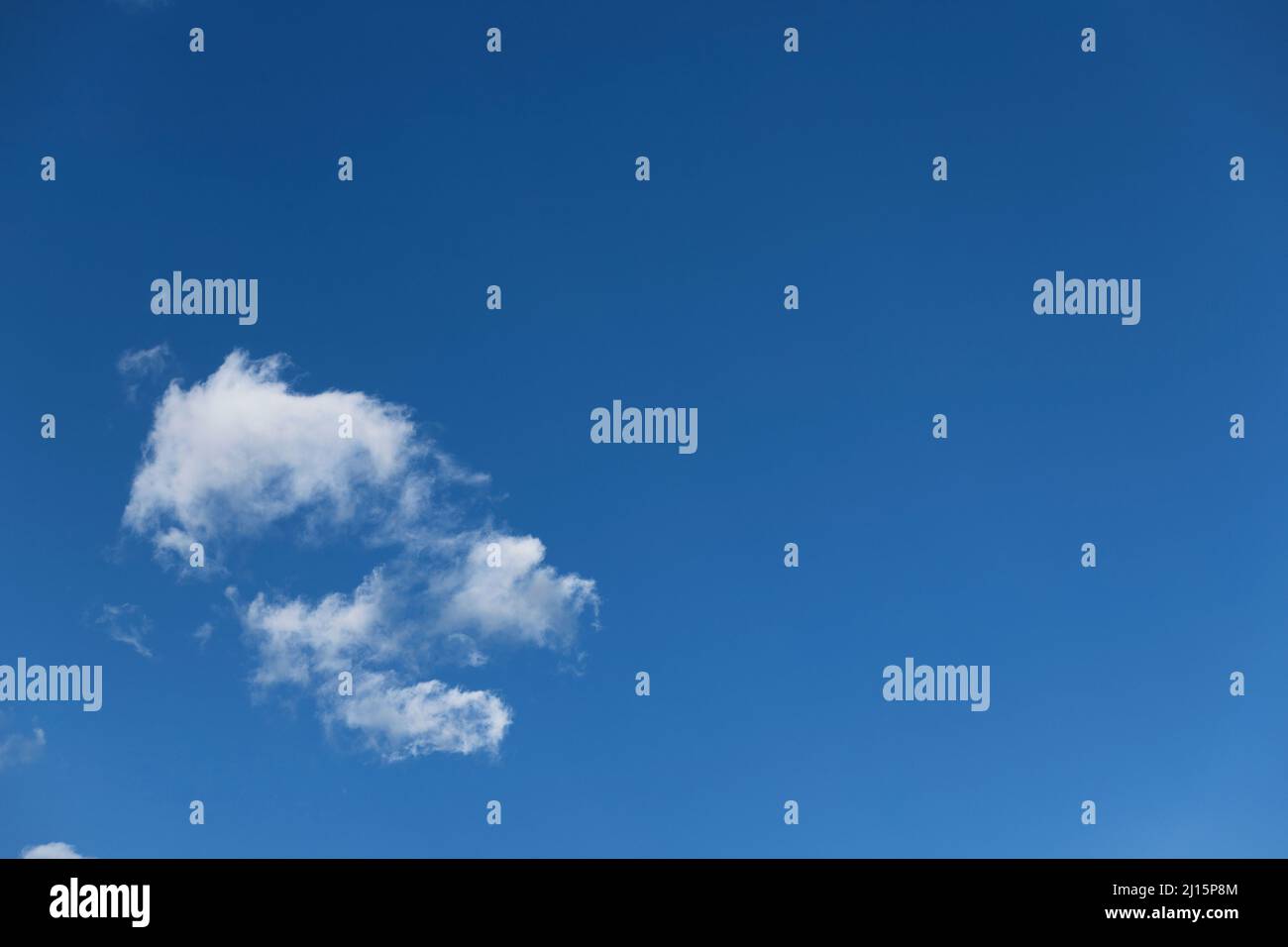 Clean blue sky with an isolated white cloud background Stock Photo - Alamy
