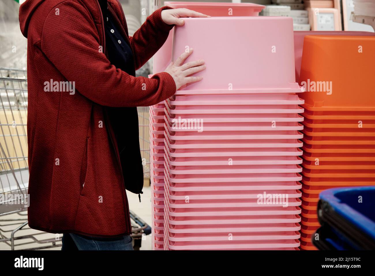 Woman in a store buys a large pink container for storing things and ...