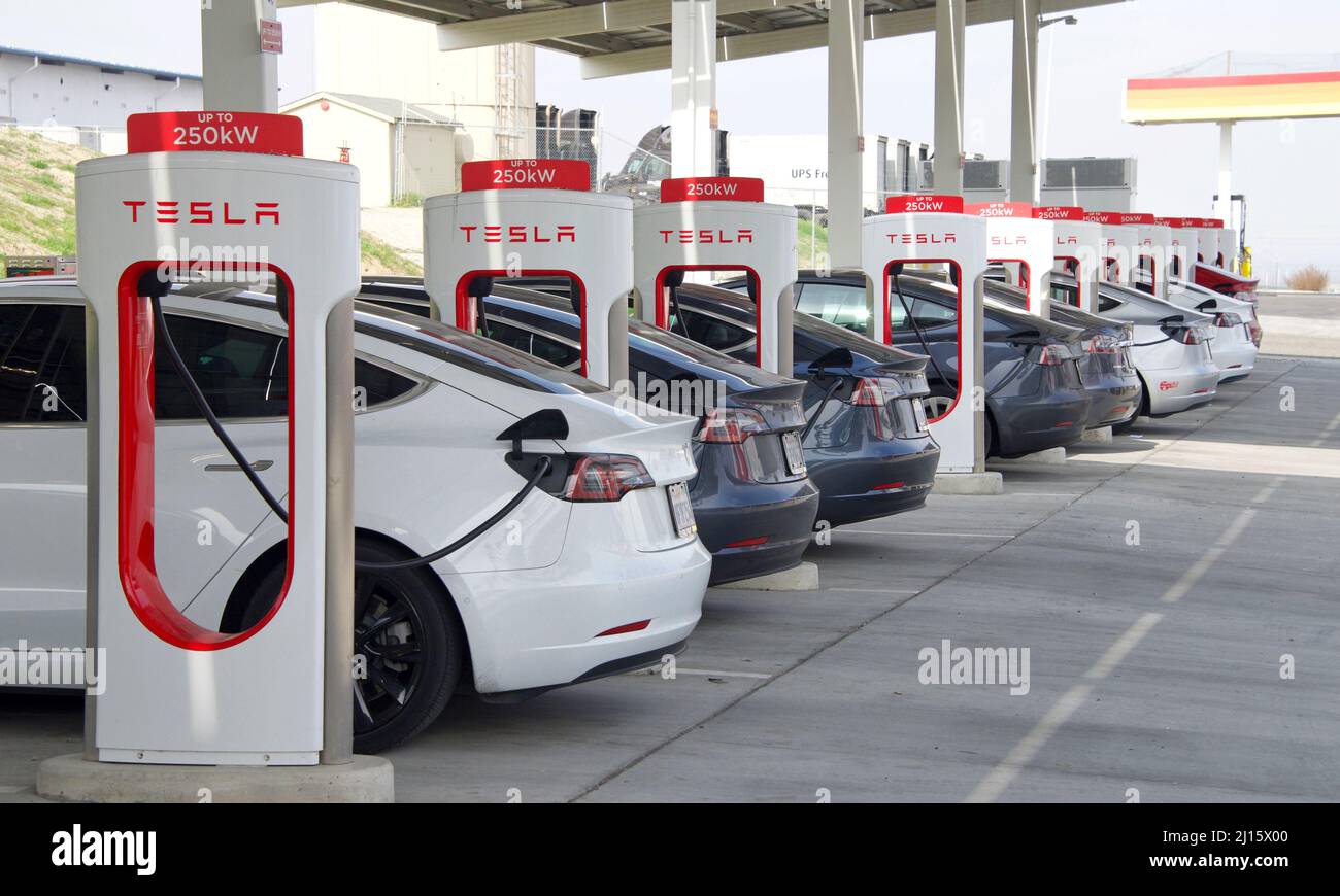 Kettleman City, CA - Jan 29, 2022: Many cars charging at a Tesla Supercharger station. Supercharger stations allow Tesla cars to be fast-charged at th Stock Photo